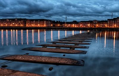 View of illuminated city at waterfront during winter