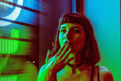 Close-up of woman smoking by window