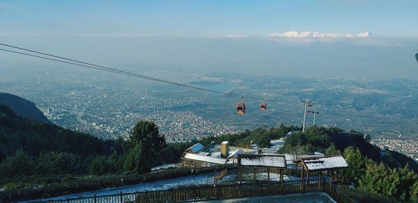 Overhead cable car over mountains against sky