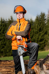 Portrait of lumberjack holding electric saw