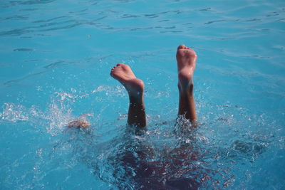 Low section of man swimming in pool