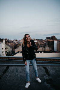 Portrait of beautiful woman standing against sky