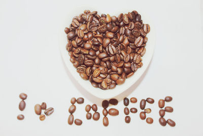 High angle view of coffee beans over white background