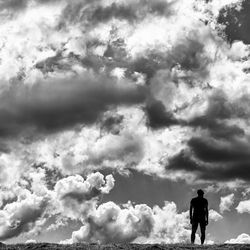 Rear view of silhouette man standing against sky