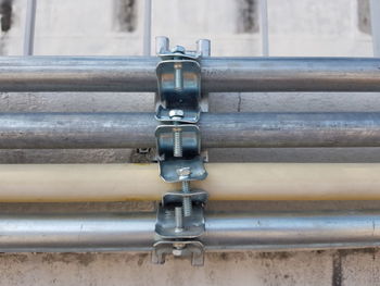 Close-up of pipe on railing against wall