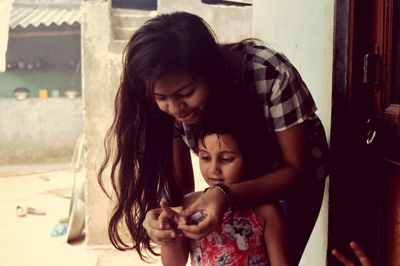 Cheerful sisters playing at home