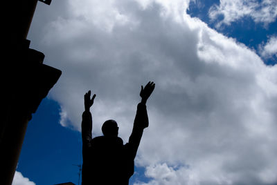 Low angle view of silhouette man standing against sky