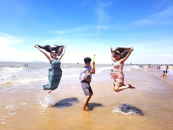 People enjoying at beach against sky