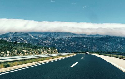 High angle view of road by cloudy mountains against sky