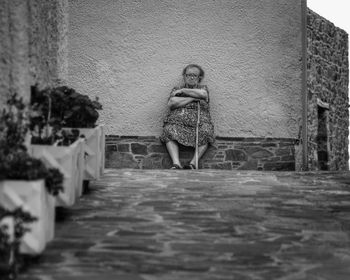 Rear view of woman standing by building