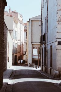 People walking in alley amidst buildings