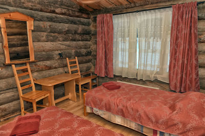 Empty chairs and table against window in house