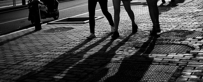 Low section of man and woman walking on sidewalk