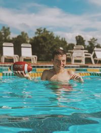 Portrait of shirtless man swimming in pool