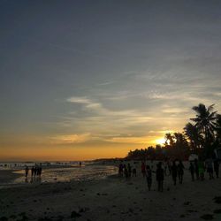 People at beach during sunset