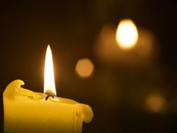 Close-up of burning candle in darkroom