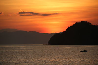 Scenic view of sea against orange sky