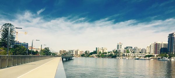 Bridge over river against cloudy sky