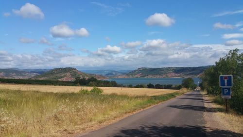 Road by landscape against sky