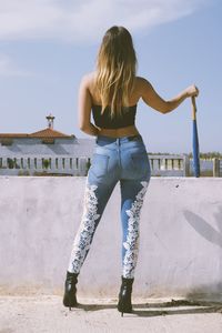 A sexy girl wearing jeans with a baseball bat at han