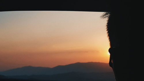 Close-up of silhouette person against sky during sunset