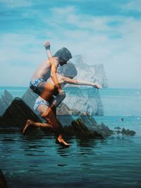 Double exposure image of girl jumping into sea