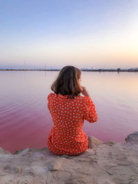 Rear view of woman at beach during sunset