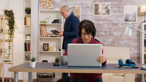 Side view of woman using laptop at table