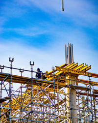 Man working at construction site against sky