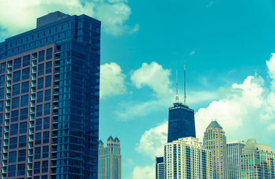 Low angle view of buildings against cloudy sky