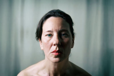 Close-up portrait of topless mature woman at home