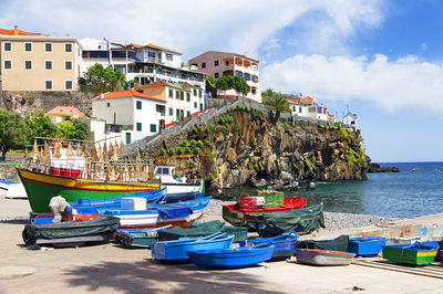 Boats on shore against built structures