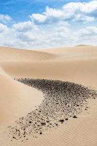 Sand dunes in desert against sky