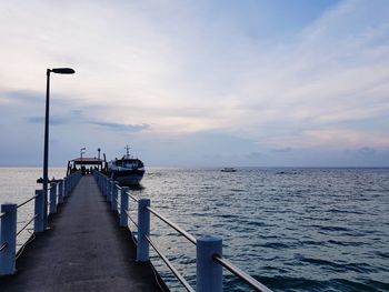 View of jetty in sea against cloudy sky