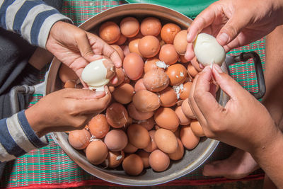 High angle view of man holding eggs on table