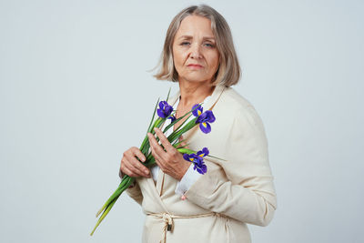 Happy woman with arms raised standing against white background