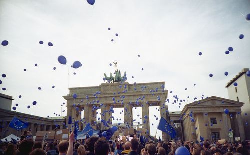 People in town square against sky