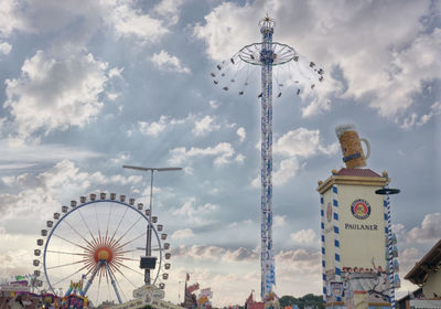 Low angle view of ferris wheel against cloudy sky