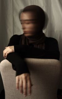 Side view of woman sitting on sofa at home