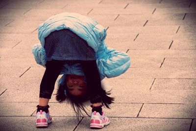 Girl peeking between legs at tama zoological park