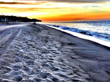 Scenic view of beach against sky during sunset