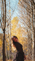 Woman standing against trees during autumn