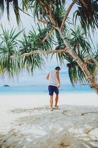 Rear view of man and woman walking on beach