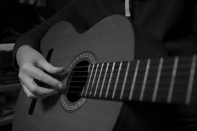 Midsection of man playing guitar