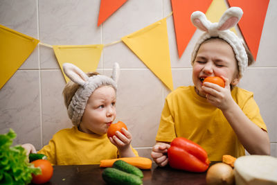 Children in rabbit ears eat herb dill vegetables easter. high quality photo