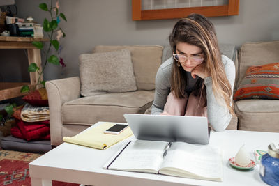 Young woman working from home on laptop during covid