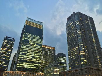 Low angle view of modern building against cloudy sky