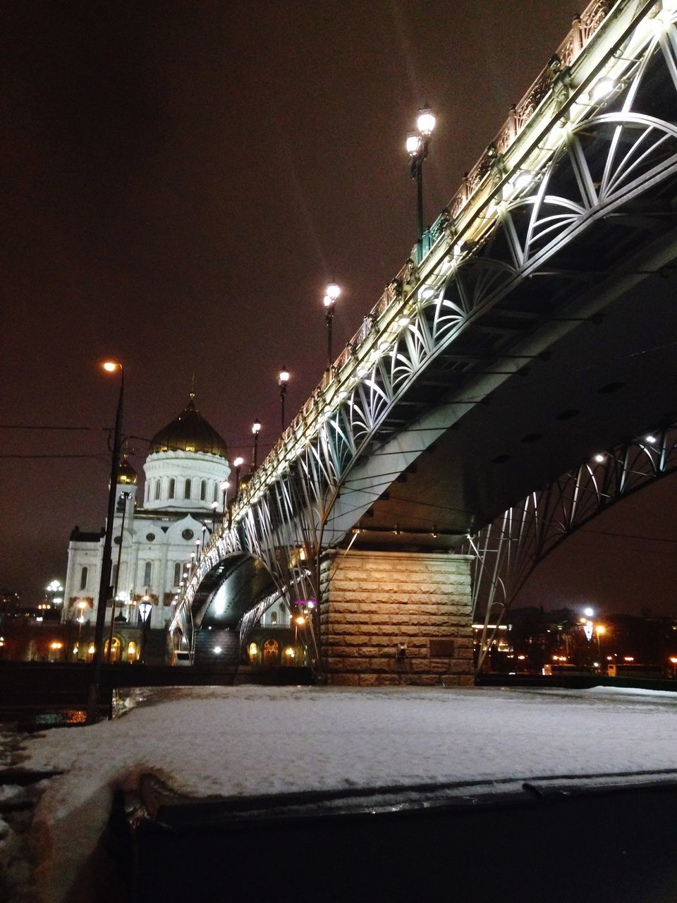 illuminated, night, architecture, built structure, connection, bridge - man made structure, engineering, street light, transportation, building exterior, sky, bridge, city, lighting equipment, low angle view, river, suspension bridge, outdoors, long, no people