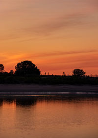 Scenic view of lake against romantic sky at sunset