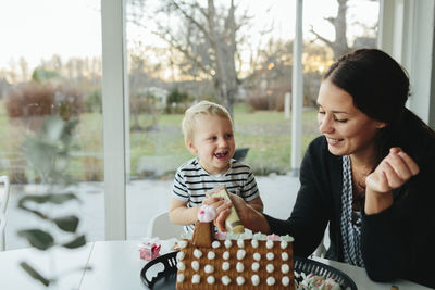 Mother with son making gingerbread house